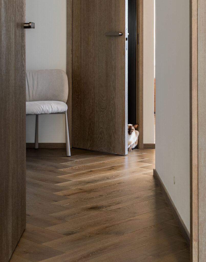 Sophisticated Simplicity: Herringbone Parquet Paired With Modern Velvet Doors