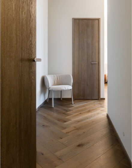 Sophisticated Simplicity: Herringbone Parquet Paired With Modern Velvet Doors